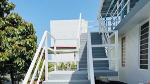 A staircase leading to a building with a white exterior and a glass section.