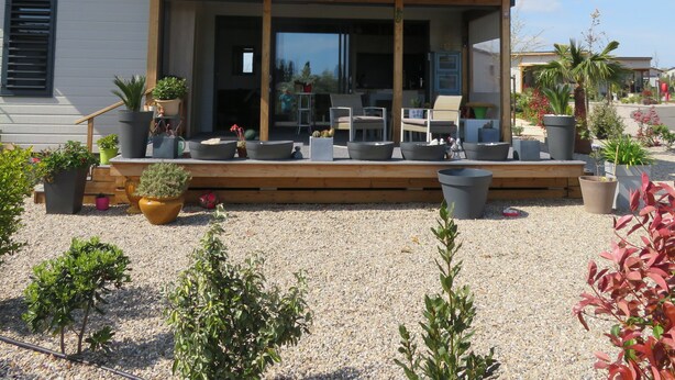 A modern house with a covered patio area, outdoor seating, and various potted plants. - 5-seater cottage in Pomérols (Pomérols)
