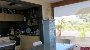 A compact kitchen with a dining area, a built-in cabinet, and a view of the outdoors. - 5-seater cottage in Pomérols (Pomérols)