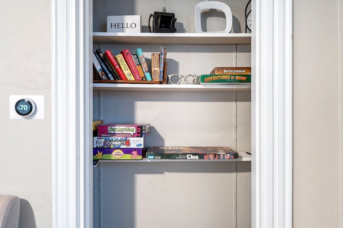 Una estantería con libros, una cámara y un letrero que dice Hello.
