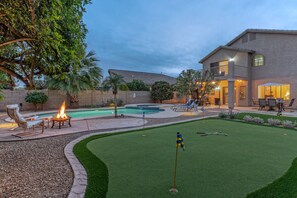 A backyard with a swimming pool, a fire pit, and a putting green. - Boulder MT Highlands: Near Golf & Trails, POOL w/Opt Heat, Spa, Putt Green, King Beds & TVs All BRs (Mesa)
