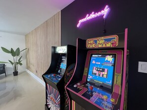 A retro arcade machine with a neon sign in the background.