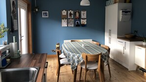 A kitchen with a dining table, wooden chairs, a hanging light fixture, and a white refrigerator. - St. Andrews House available for the Open (St Andrews)