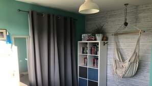 A room with teal walls, a white bookshelf filled with books, a hammock, and a desk with a chair. - St. Andrews House available for the Open (St Andrews)