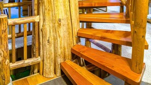 A wooden staircase with a rustic design, surrounded by wooden walls and benches.