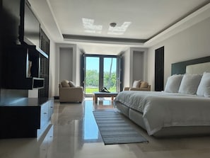 Relax in a spacious room with a large bed, flat-screen TV, and seating area.