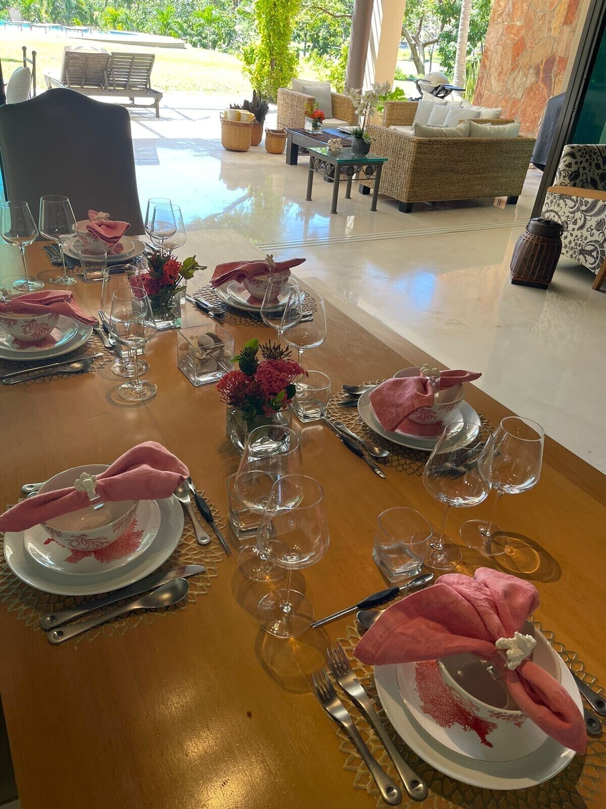 Una mesa lista para servir una comida, con varios platos, vasos y cubiertos.