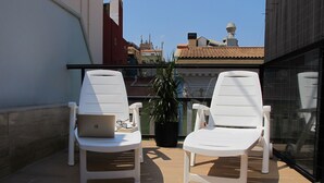 Two white lounge chairs with a laptop and a book on one, and a potted plant between them. - Spectacular penthouse with terrace, 2 bedrooms (Alicante (Alacant))