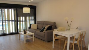 A modern living room with a sofa, a coffee table, and a dining table with chairs. - Spectacular penthouse with terrace, 2 bedrooms (Alicante (Alacant))