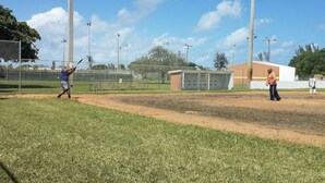 Un campo de béisbol con un bateador, un receptor y un árbitro.