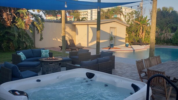 Ein Garten mit Whirlpool, Sitzgelegenheit im Freien und einem Schwimmbecken.