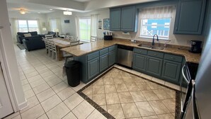 Una cocina amplia con encimeras de granito, lavavajillas y una isla grande.