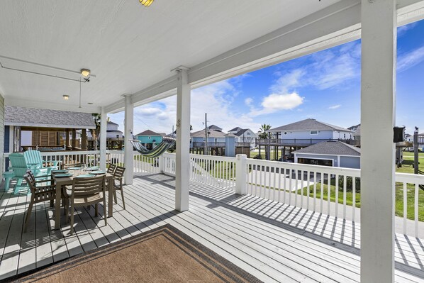 Relax in this serene outdoor space with a dining table and hammock overlooking a residential neighborhood.