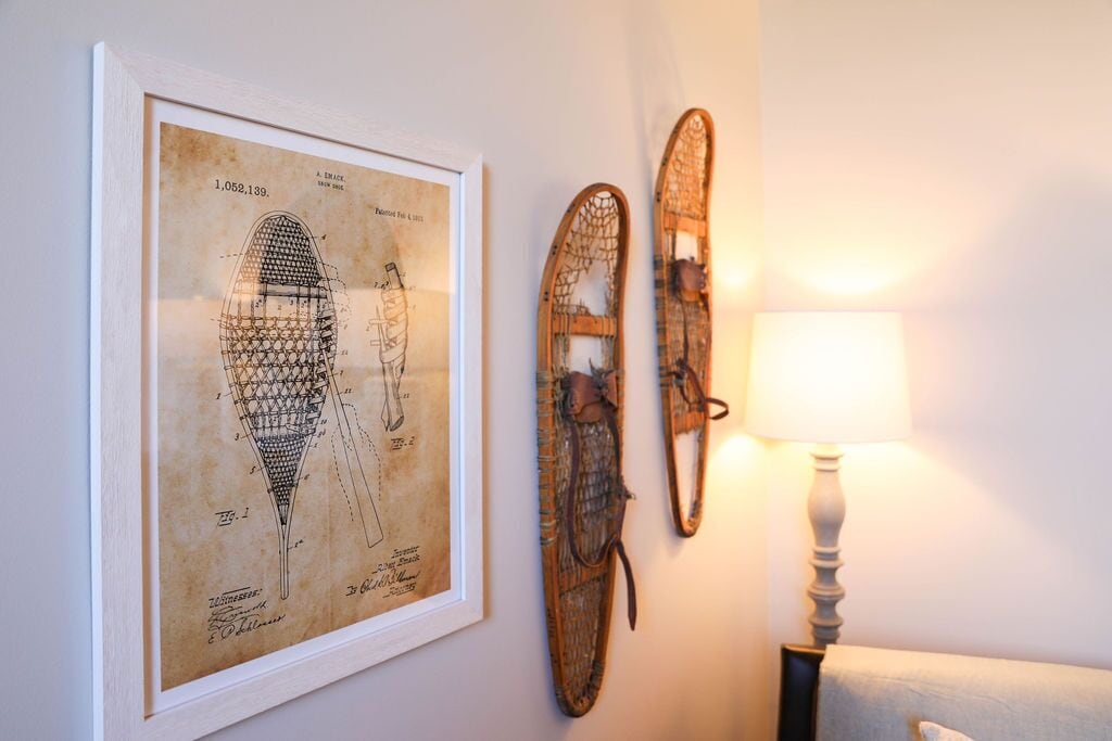 A framed technical drawing, two wooden objects, and a lamp on a wall.