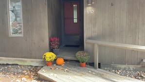 Un bâtiment en bois, avec le numéro 632 inscrit sur le mur, une porte et deux plantes en pot sur le porche.