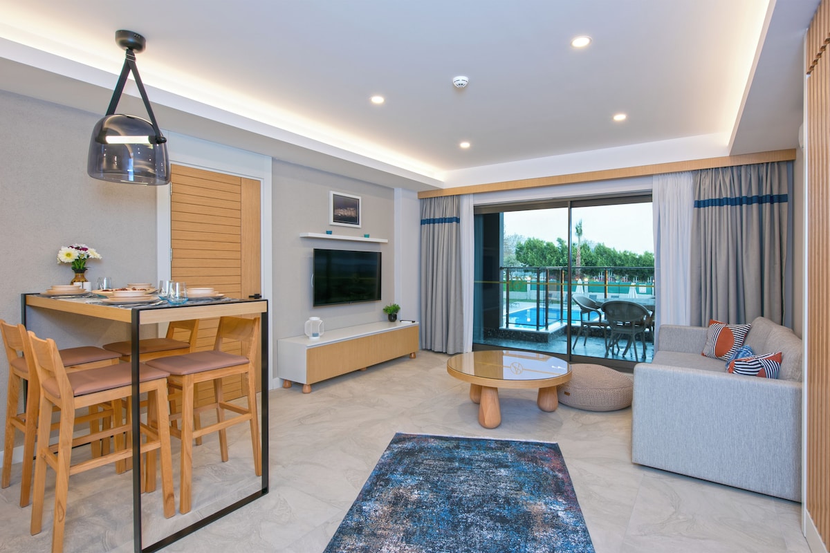 A modern living room with a dining area, a TV, a pool view, and a cozy seating area.