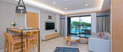 Una sala de estar moderna con comedor, televisor de pantalla plana, sofá y vista a una piscina.