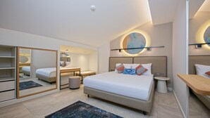 A modern bedroom with a large bed, bedside tables, a mirror, and a round wall light. - A Suite Side (Manavgat)