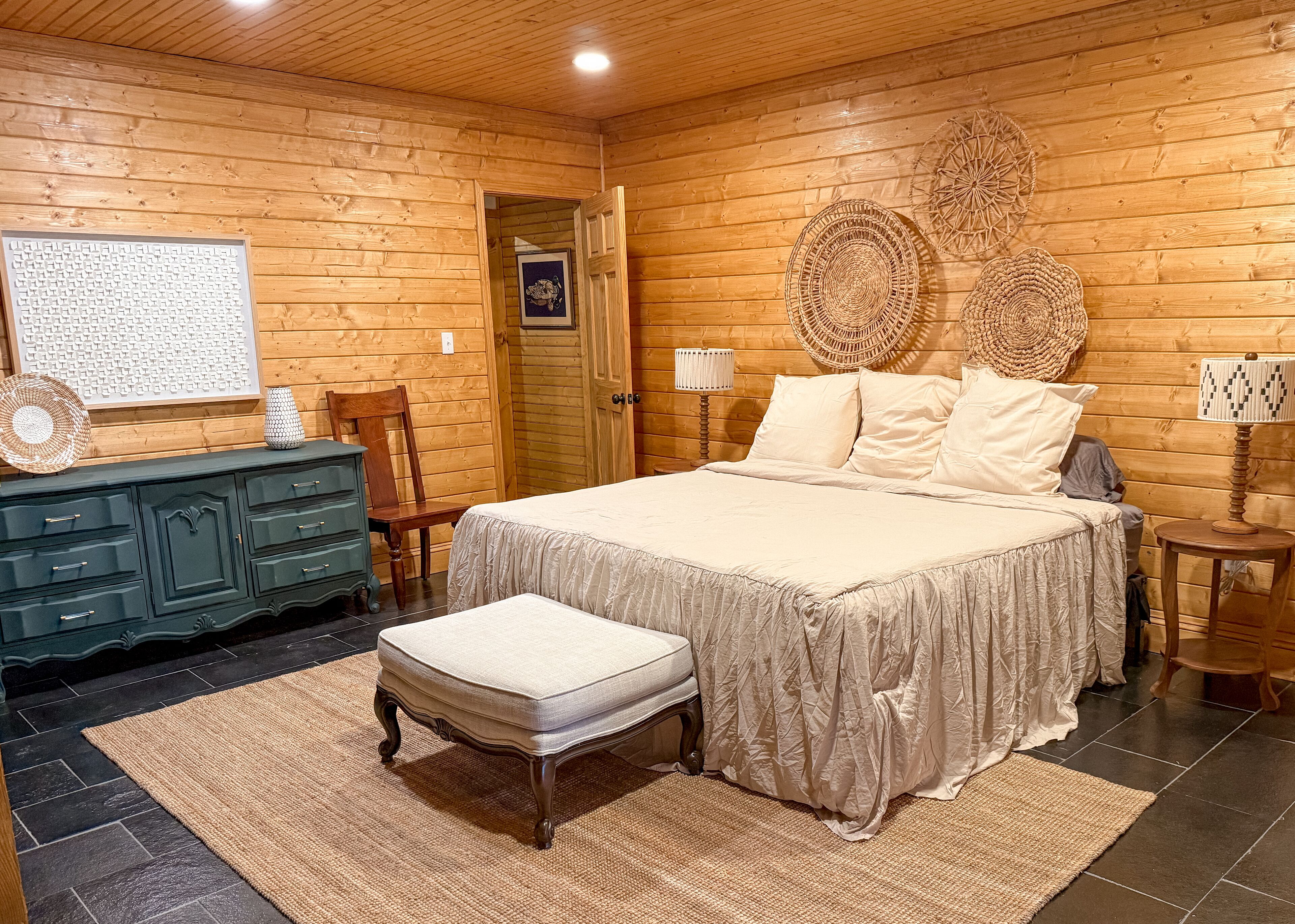 Une pièce chaleureuse en bois, avec un lit, une commode et une chaise.