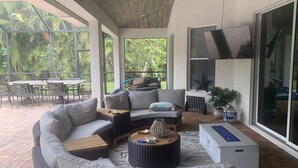 A modern outdoor living area with a sofa, coffee table, and dining set.
