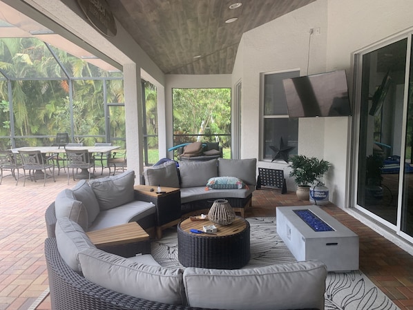 A modern outdoor living area with a sofa, coffee table, and dining set.