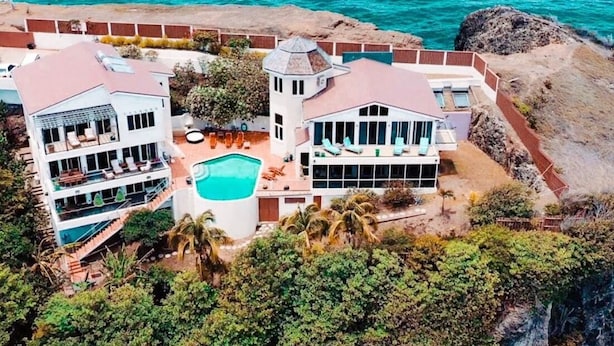 Ein Küstenanwesen mit Pool, mehreren Balkonen und Meerblick.