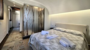 A hotel room with two beds, a mirror, and a patterned carpet. - Suite Amalfitania, Ortigia, Syracuse. (Siracusa)