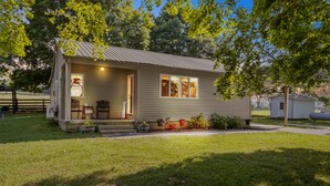 A single-story house with a front porch, a small attached garage, and a well-maintained lawn.