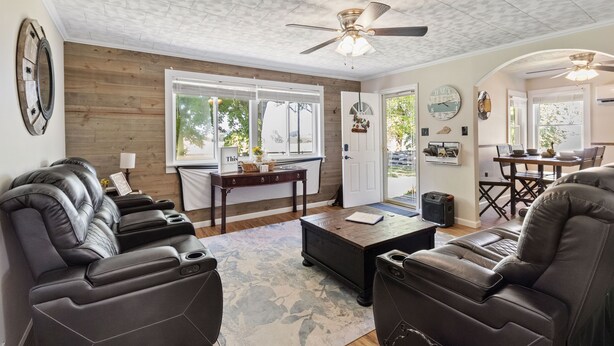 A living room with leather recliners, a coffee table, and a ceiling fan.