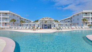 A hotel with a pool, multiple balconies, and a covered entrance.