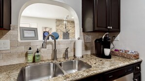 A kitchen with a double sink, a coffee maker, and a wicker basket on the countertop. - Updated home in safe, quiet neighborhood with lots of amenities! (San Diego)