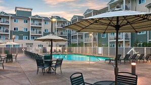 A poolside area with outdoor seating and umbrellas. - Long Beach WA  Oceanfront 4th of July week (Long Beach)