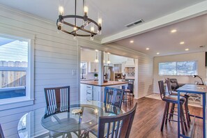 A spacious kitchen with modern appliances, a dining area with a glass table, and a view of the backyard.