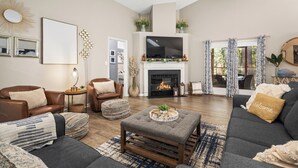 A living room with a fireplace, sofas, a coffee table, and a television.