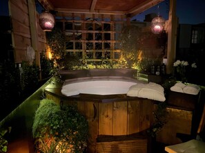 Een hottub met houten banken en een overkapte houten pergola.