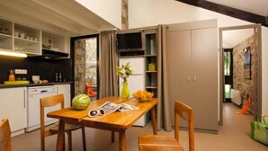 Une cuisine de taille réduite avec une table en bois, des chaises et un réfrigérateur.