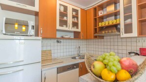 A kitchen with wooden cabinets, a microwave, and a fruit bowl on the counter.