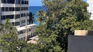 A high-rise building with multiple balconies overlooking a beach. - Lovely beach studio - High speed internet! (San Juan)