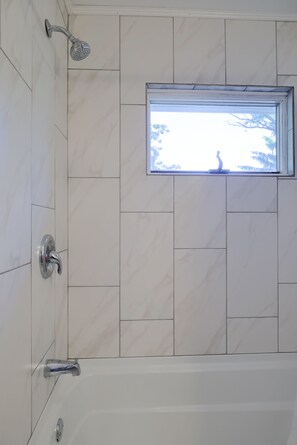 Bathtub, hair dryer, towels, toilet paper
