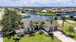 A residential area with houses, a canal, and a large building with a garage. - Surfside - Bikes and Weight Bench (Cape Coral)