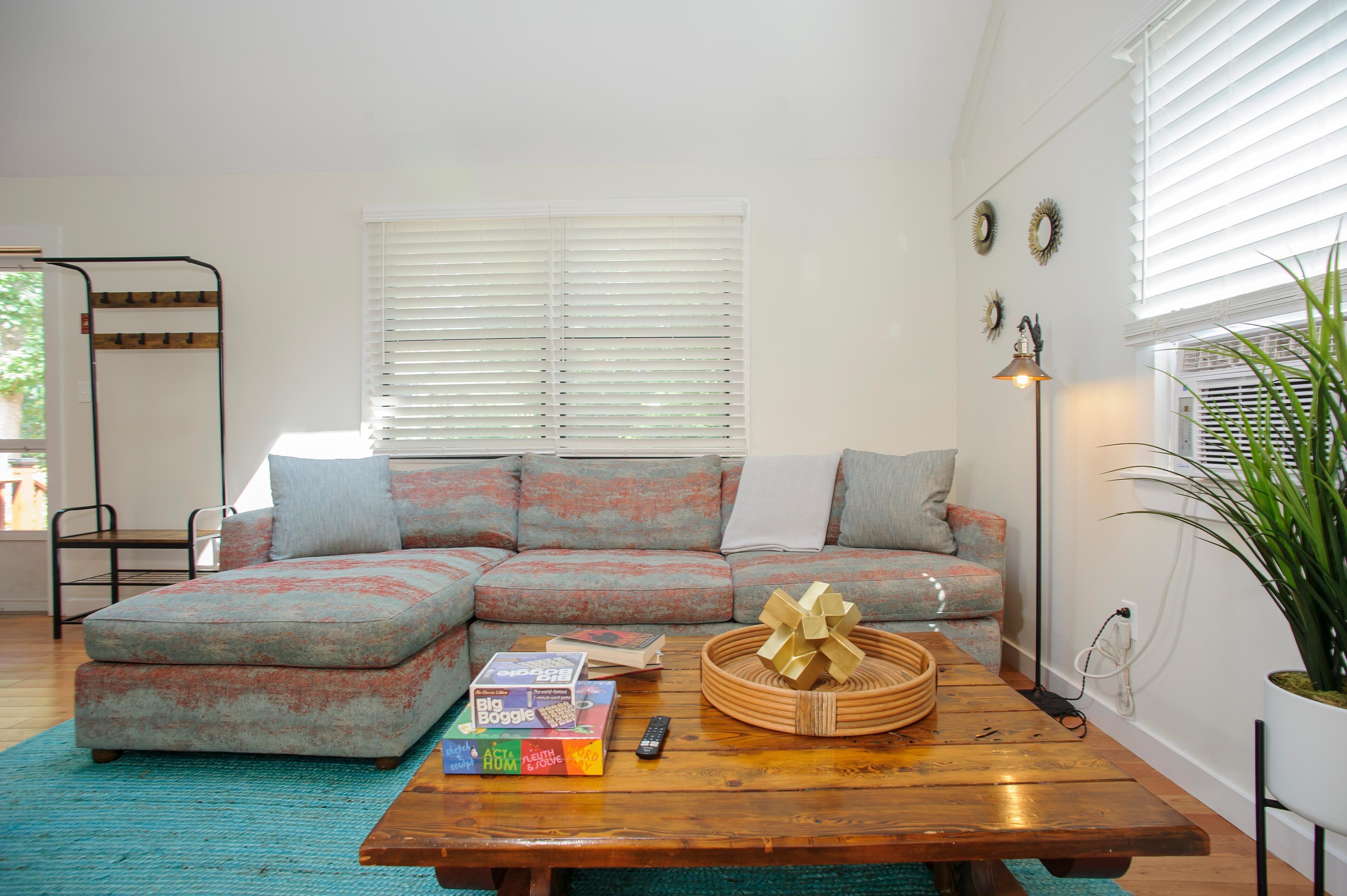 Una sala de estar acogedora con un sofá modular, una mesa de centro de madera y una planta en maceta.