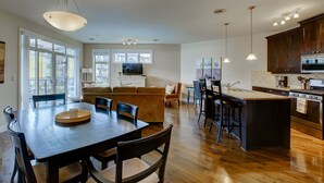 Une cuisine spacieuse avec un coin repas, un plancher en bois et des appareils électroménagers modernes.