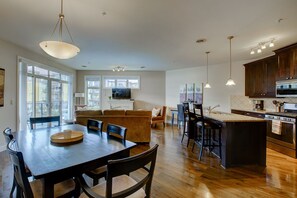 A spacious kitchen with a dining area, wooden flooring, and modern appliances.