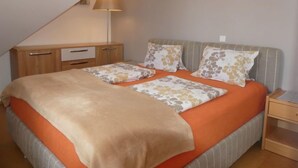 A bedroom with a bed, a nightstand, a lamp, and a wardrobe. - Anneliese by Interhome (Saalfelden am Steinernen Meer)