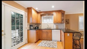Una cocina con armarios de madera, una encimera y un lavavajillas empotrado.