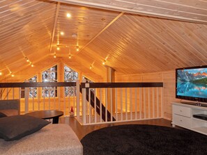A cozy interior with a wooden ceiling, a TV, a sofa, and a staircase leading to a balcony. - Vacation home Tiera by Interhome (Salla)