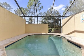 A swimming pool with clear water, surrounded by beige walls and a metal roof structure. - Featured- 3 Bedroom 3 Bath Private Pool! Windsor Hills (Kissimmee)