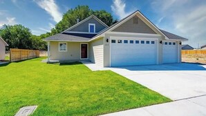 Ein eingeschossiges Haus mit Garage, Vorgarten und blauem Himmel.