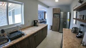 A modern kitchen with a granite countertop, stainless steel appliances, and wooden cabinets. - Beautiful house w heated private pool/ downtown (Tequisquiapan)