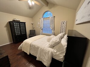A bedroom with a bed, a dresser, a chair, a window with curtains, and a wall decoration. - NE Houston, Whole House, 3 bed 2 bath, 15 min from IAH Airport (Humble)